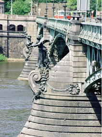 写真：チェフ橋の橋脚の上には，上流側ではトーチカを持った女性像，下流側にはプラハの紋章を守る6頭のヒュドラ（ギリシャ神話上の蛇）の彫刻が飾られている
