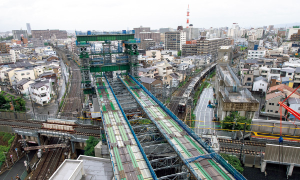 図版：千里線方面に延びる軌条桁。右奥の列車は京都線、手前を横切る線路はJRおおさか東線