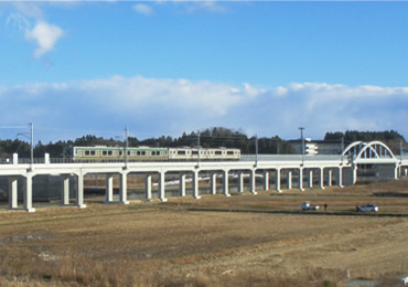 図版：完成した坂元川橋梁を走る運行再開した常磐線