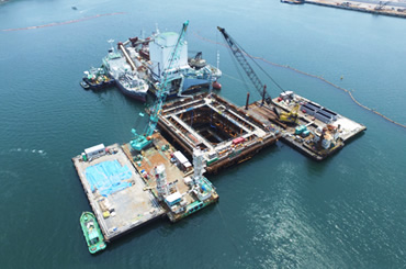 図版：頂版コンクリート打設時のドローンによる撮影、奥にコンクリートプラント船が見える（2017年6月9日）