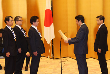 図版：安倍内閣総理大臣より表彰状を受け取る滝口紀夫所長