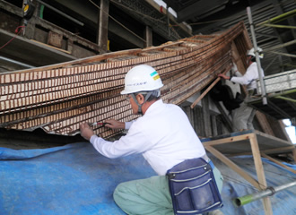 写真：四重屋根の千鳥破風部にステンレス釘にて、木摺を取付けているところです。