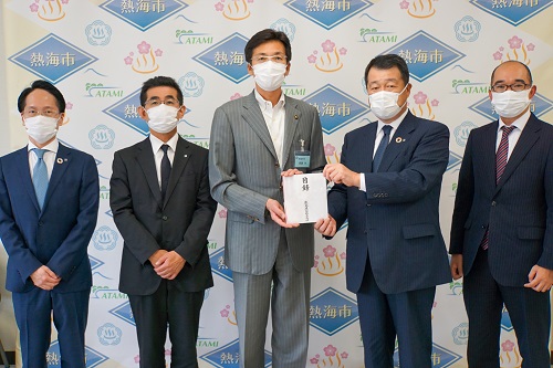 Deputy General Manager Matsuda (second from the right) handing a list to Mayor Saito (center)