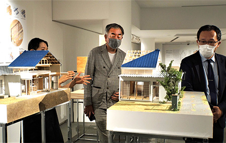 Kengo Kuma (center) and Yasutaka Konishi looking at exhibited works