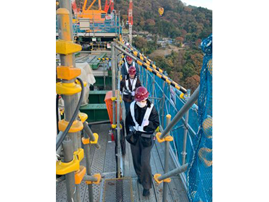 Image: Scholarship students looking at the construction site from scaffolding