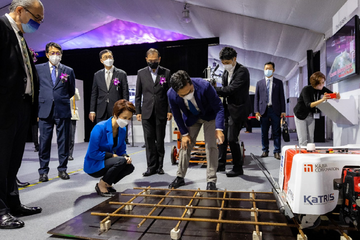 Minister Low studying the Rebar Tying Robot developed by Kajima Corporation during the tech tour showcase.