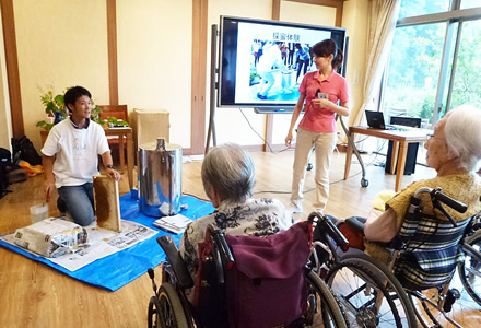 写真：採蜜実演中。ご希望者には、遠心分離機を回していただきました。