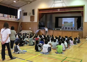 写真：小学校の体育館での稲作に関する授業のようす