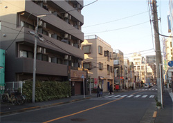 現在は7階建ての賃貸マンションが建っている。道路右側の2本の横断歩道の間あたりに本門寺道駅があった。