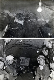 どちらも東北電力松神発電所工事（青森県）。上の写真は昭和29（1954）年4月23日、導坑4800m地点を削岩機2基で削孔中。カッパ型と言われるごく初期の形状のヘルメットをかぶっている。下の写真は第2号隧道工事下口完成祝。同じ年の5月29日。