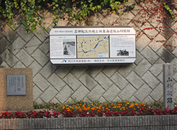 高速道路わきの「名神高速道路起工の地」の碑。右は山科駅跡の碑