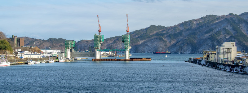 図版：上流側から見る閉伊川河口部。左岸側3基の堰柱の構築が完了している（2021年1月）