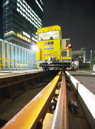 深夜の東京駅の近くに佇む運搬台車。レールは新幹線ホームへとつながるの写真