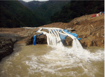 写真：天然ダム湖の水位を下げるため，ポンプで排水