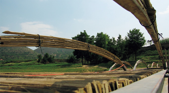 写真：橋の床面と手すり。裂いた竹を重ね合わせて床や手すりをつくるため，空隙が生まれ水の抵抗が軽減される。一定の抵抗を上回ると部材が橋から離れて水に流されることになる。その場合は，村にある竹を切り取って住民が修理することができる