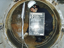 写真：小河亮介工事係。直径約1mの鋼管内で地中障害物を確認