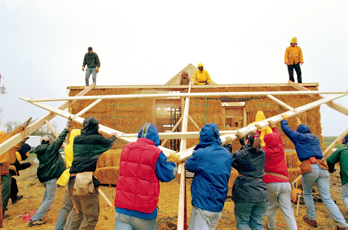 写真：ストローベイルハウスは，多くの人が協力しあって建てられる。地域住民は家づくりのノウハウを学び，ボランティアは彼らとの協働を通じてネイティブ・アメリカンの歴史や生活の理解を深める