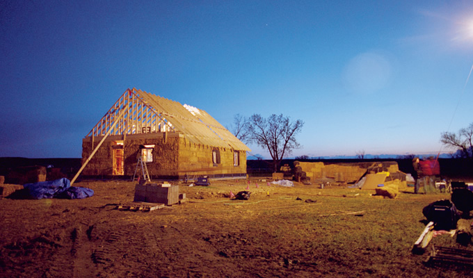 写真：基礎づくりから屋根を架けるまで，建設期間はわずか3週間ほど。短い期間で家づくりのノウハウをコミュニティに伝授する