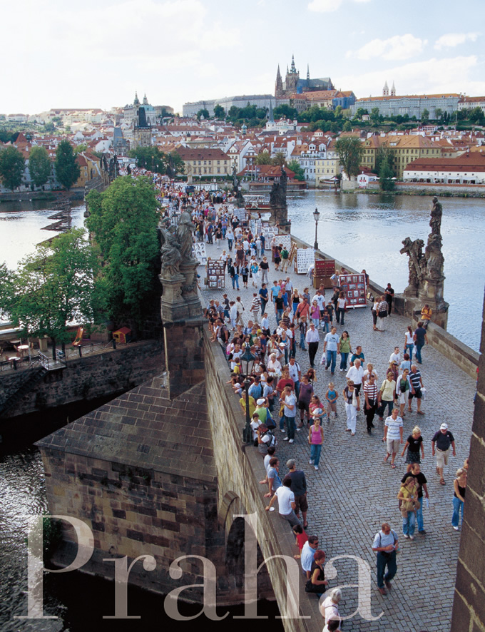 写真：いつも観光客であふれているカレル橋の橋上。撮影場所の東側の塔の上からはプラハ城の全景が見渡せる