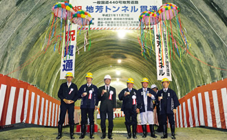 写真：2009年11月7日，貫通式に臨んだ田代副社長（左から4人目）と松川所長（その右）