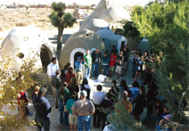 写真：完成したエコドームの前で建設に携わった住民やスタッフに語りかけるネーダー・ハリーリ（写真中央の人物）