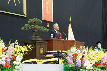 図版：押味会長の横で伏せをして待つSpot