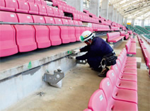 写真：修復作業。被害箇所は広いスタジアムの各所に点在