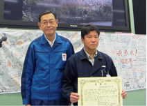写真：震災当初からの懸命な作業に対して，東京電力福島第一原子力発電所の吉田昌郎前所長（左）から感謝状を授与された