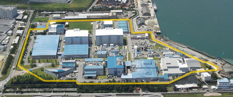 図版：上空から見た大塚製薬工場松茂工場。事業所一帯を囲う防潮堤を築いた（黄色部分）