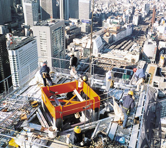 ビルの最上段にて本設クレーンの設置を準備中