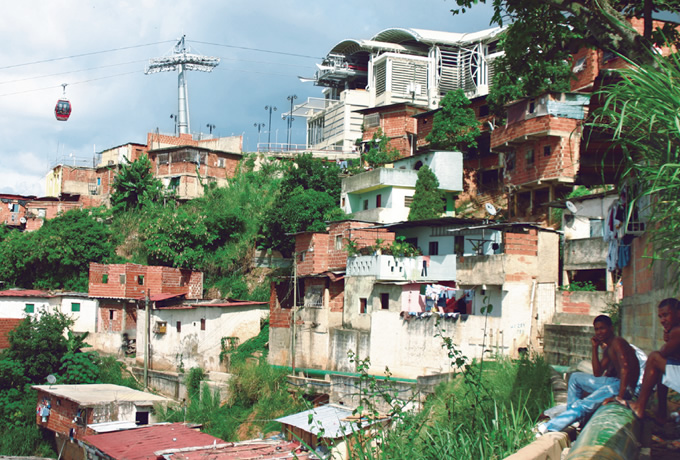 写真：密集する低層住宅の上空をロープウェイが移動する。再開発によって多くの住宅を破壊することなく，住民が必要とする移動手段を提供した