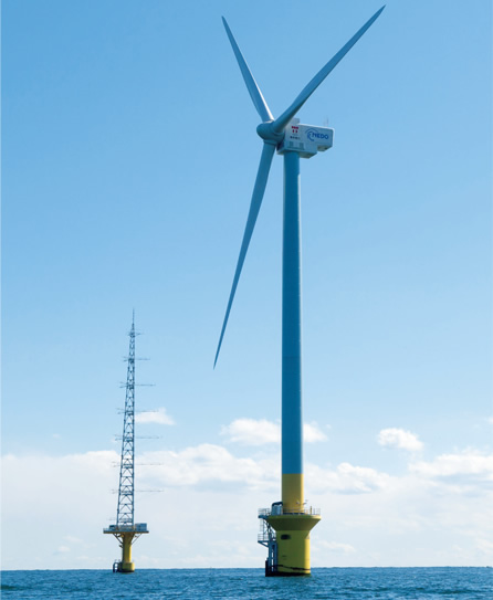 図版：完成した洋上風車（手前）と風況観測タワー