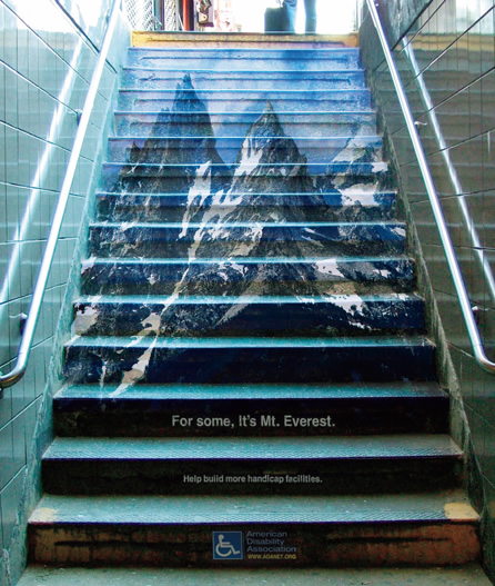 写真：「人によってはこの階段がエベレストのようにも感じられる」。
地下街の階段に記されたのは，エレベータ設置を呼びかけるアメリカ障がい者協会のメッセージ