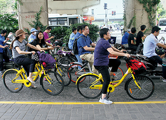 写真：若者たちが乗るのは最新システムのシェアリング自転車