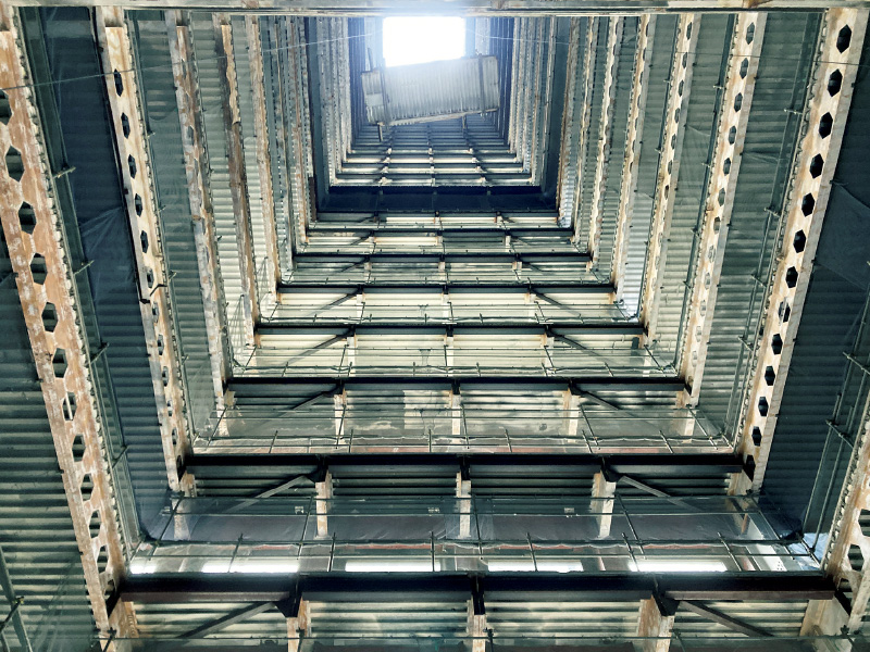 図版：40階分を貫いている揚重開口から吊り下ろされる大割ブロック
