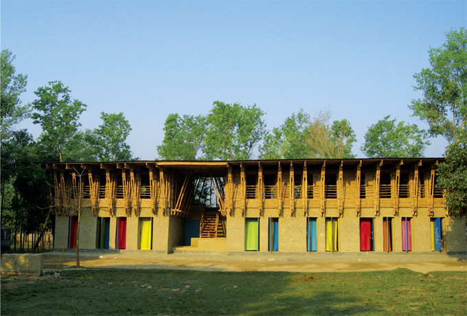 写真：1, 2階で素材の違う校舎。竹のフレームや色鮮やかなカーテンが楽しげな印象を与える