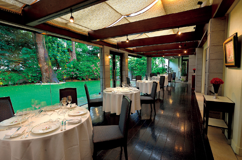図版：レストラン内観。窓越しに樹齢100年を超す楠が見える
