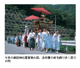 今年の御嶽神社里宮例大祭。法枠壁の前を練り歩く祭りの列