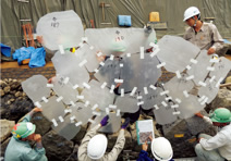 写真：“半同心円型落し積み”の石材配置を確認する工事関係者