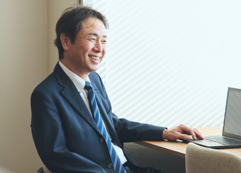 清潔感のあるオフィスで、穏やかな表情を浮かべる右上肢障がいの男性社員の写真