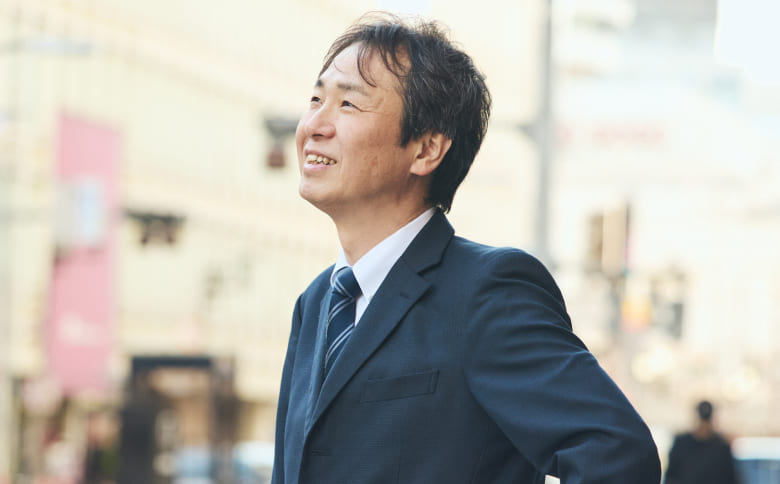 右上肢に障がいのある事務職社員の笑顔のバストアップ写真