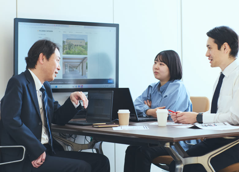 右上肢障がいの男性社員を囲み、チームメンバーが互いに信頼を寄せ合っている温かい雰囲気の集合写真