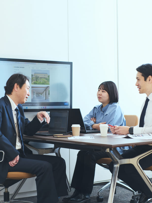 右上肢障がいの男性社員を囲み、チームメンバーが互いに信頼を寄せ合っている温かい雰囲気の集合写真