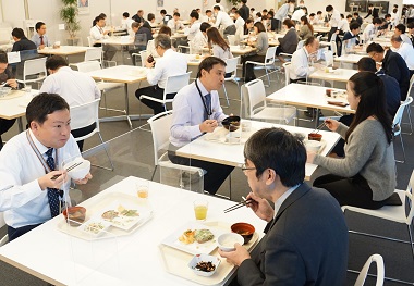 図版：本社社員社食で新米を味わう社員