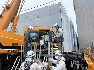 図版:静止したクレーン車に試乗し記念撮影