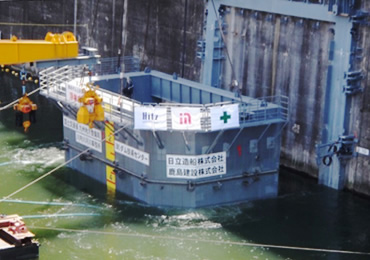 図版：鶴田ダム再開発工事で曳航される浮体式扉体