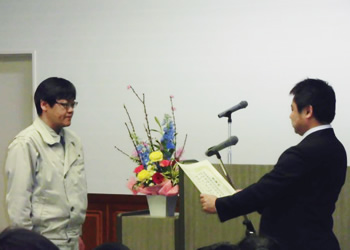 図版：普代村教育振興運動推進委員会佐藤委員長から感謝状を受ける乙竹所長（左）