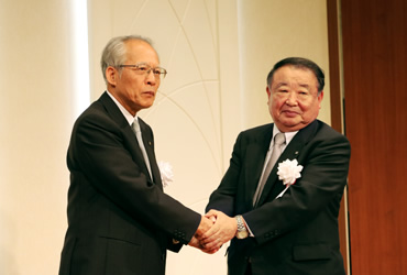 図版：廣瀬前土木学会長（左）と握手を交わす田代新土木学会長