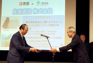 図版：中川環境大臣から任命書を授与される福田技術研究所長（右）