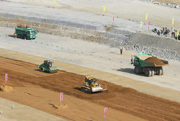 図版：展望台から見る自動ダンプトラック、自動ブルドーザ、自動振動ローラの連携作業の様子